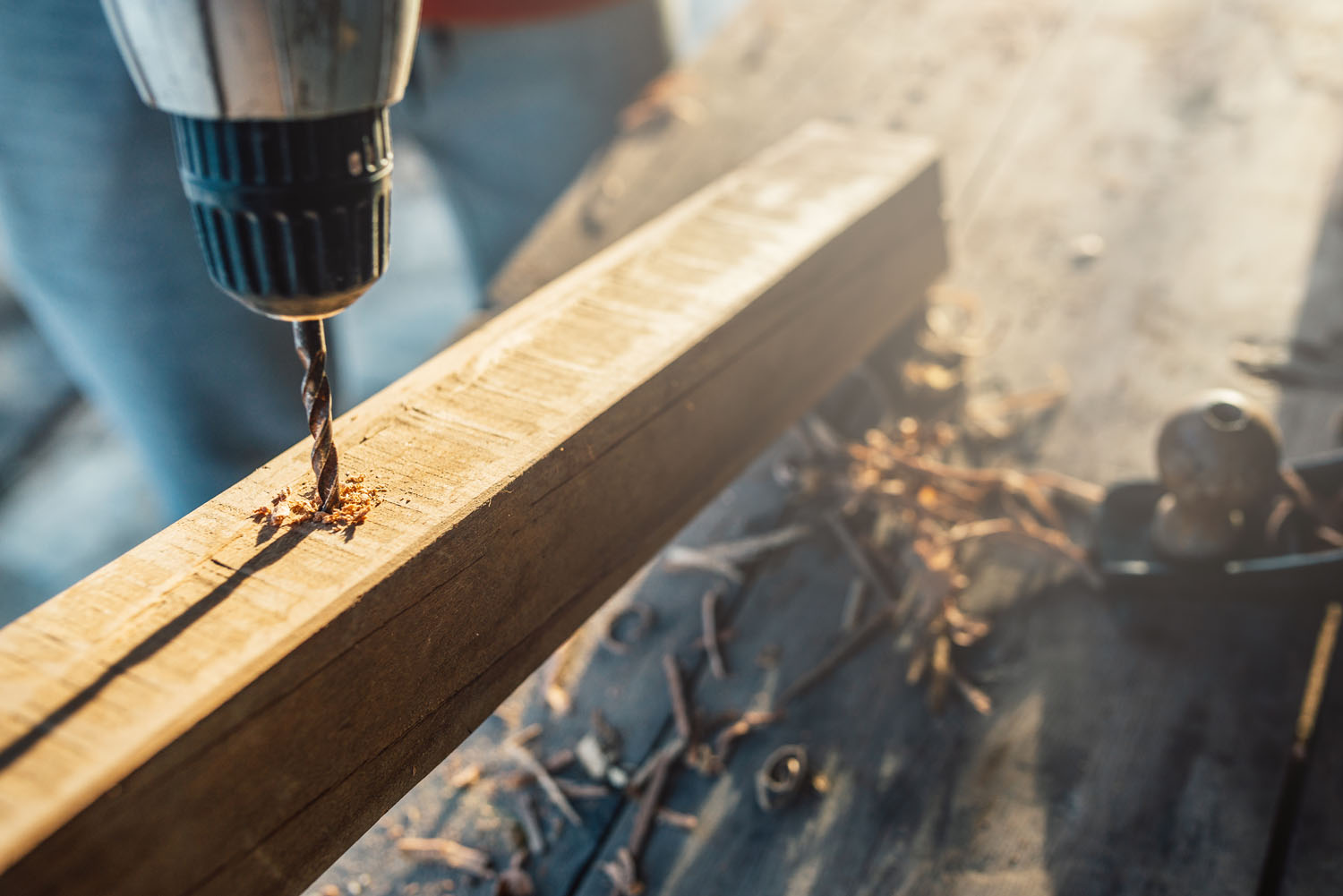 worker drills a hole in the bar with a screwdriver connect makin